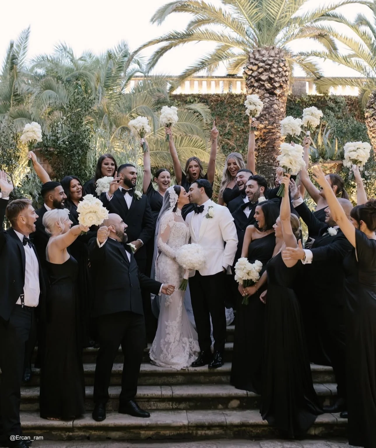 Wedding party wearing black occasion dresses at a palm garden celebration